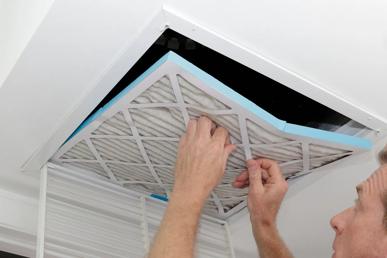Technician cleaning an air duct vent in a Redmond home
